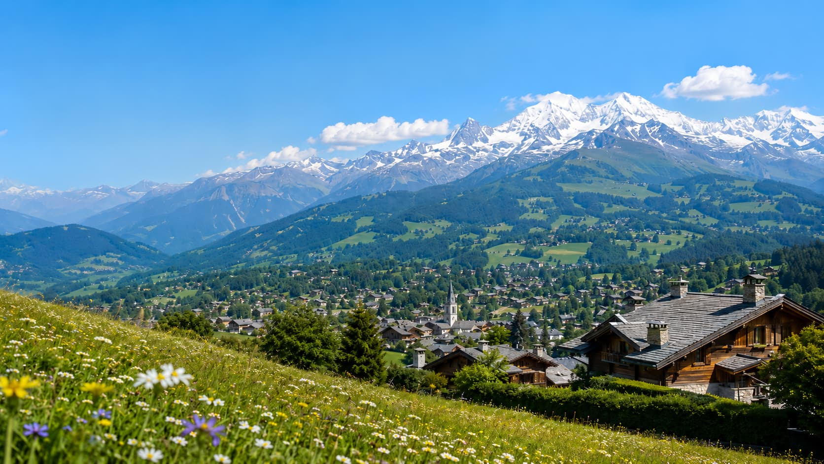Megève village and the Mont Blanc massif in summer, seen from a wildflower meadow above the town